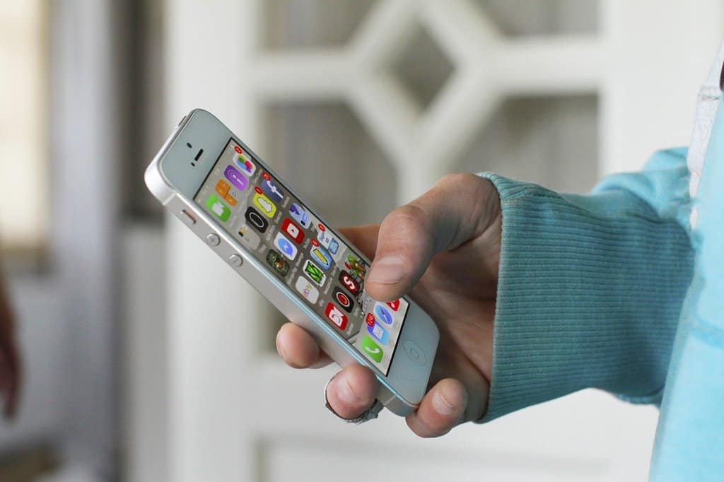 a person looks for apps on their phone to help them monitor their travel plans.