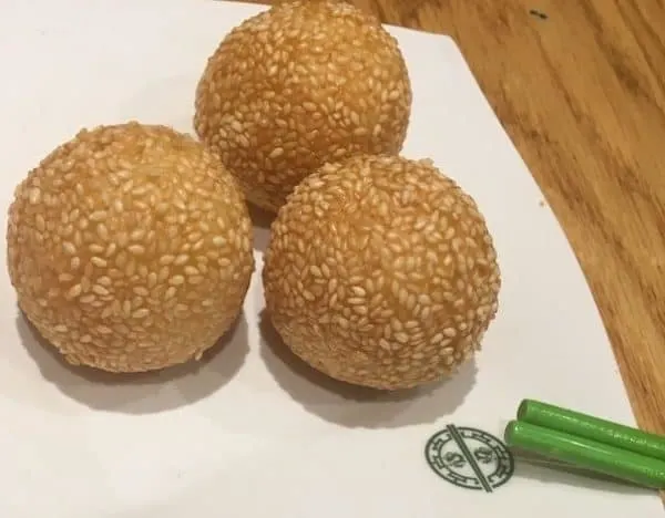 these custard-filled, sesame-coated dumplings are a dessert dim sum and the best thing to order at tim ho wan on 9th aveneue in new york city.