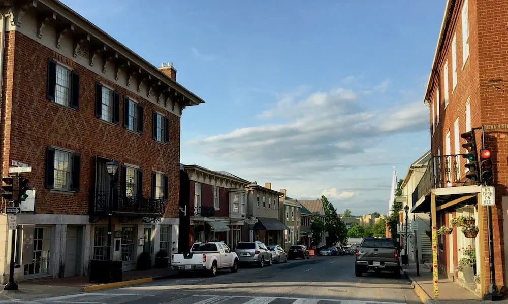 lexington, va: one of it's charming shopping streets of one- and two-story brick buildings and vma in the background 