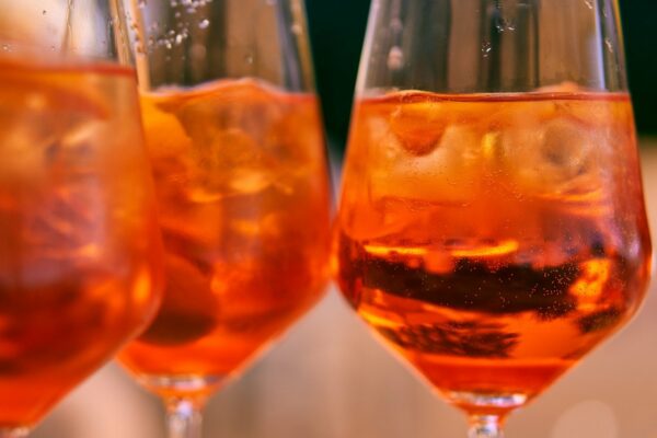 These spritzes in wine glasses get their lovely red-orange hue from the orange-flavors aperol bitters.