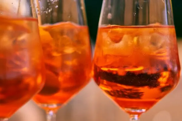 8 Molto Bene Ideas Staycation Italian Night Theme Party these spritzes in wine glasses get their lovely red-orange hue from orange-flavored aperol bitters.