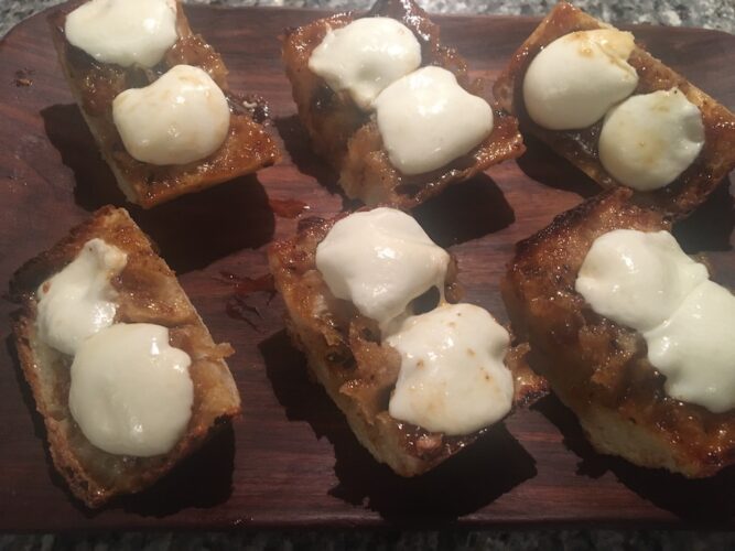 Finished bruscetta are hot and golden brown with bubbling balsamic onion jam and mellted mozzarella.