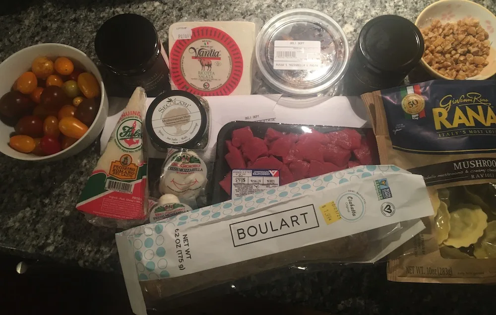 8 Molto Bene Ideas Staycation Italian Night Theme Party raw ingredients assembled for an staycation italian theme night, including cheese, bread, pasta, meat, and flavorful spreads to use as shortcuts.