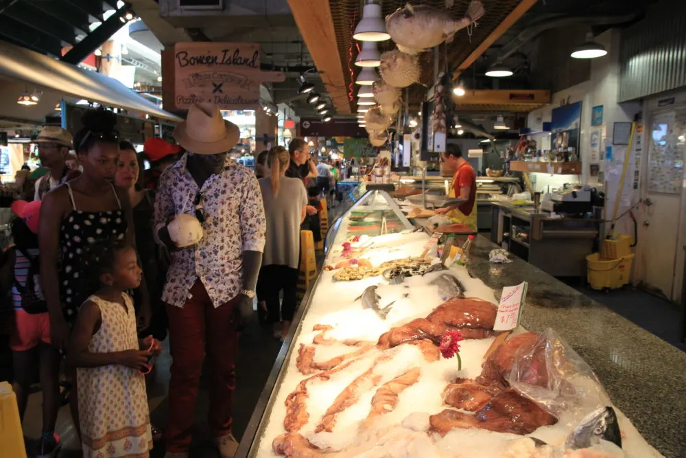 a family looks at the seafood on sale at lonsdale market in vancouver.
