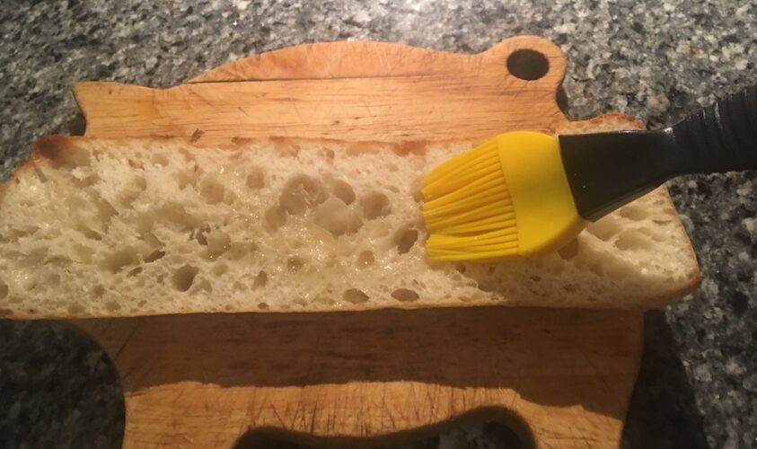 Brushing a lightly toasted ciabbatta with olive oil