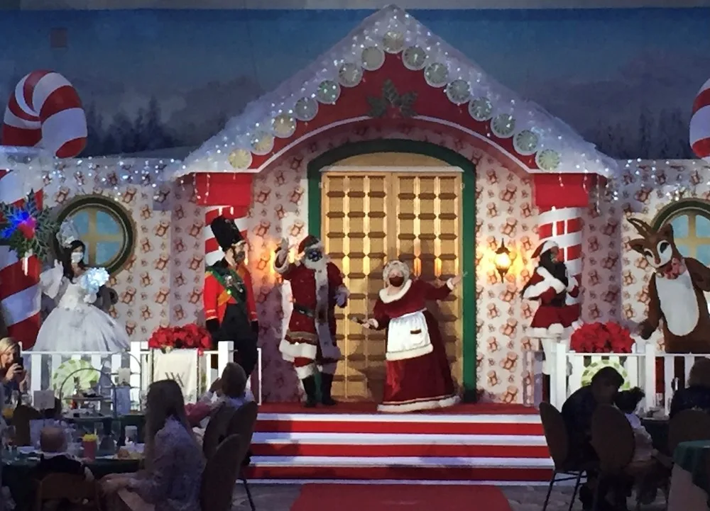 sant and mrs claus, a princess, toy soldier and reindeer emerge from a north pole cottage at the roosevelt hotel's teddy bear tea.