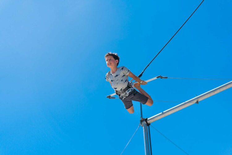 a boy flies on a trapeze at club med sandpiper, a florida beach resort with a circus school. it's a rare all-inclusive beach resort within the u.s.