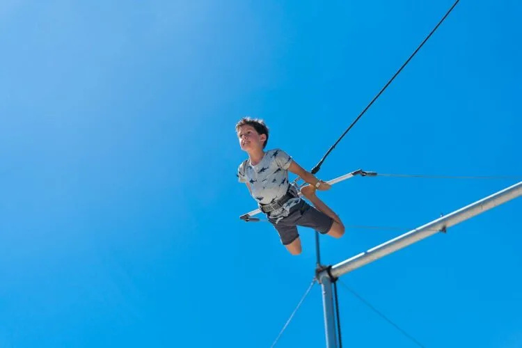 a boy flies on a trapeze at club med sandpiper, a florida beach resort with a circus school. it's a rare all-inclusive beach resort within the u.s.