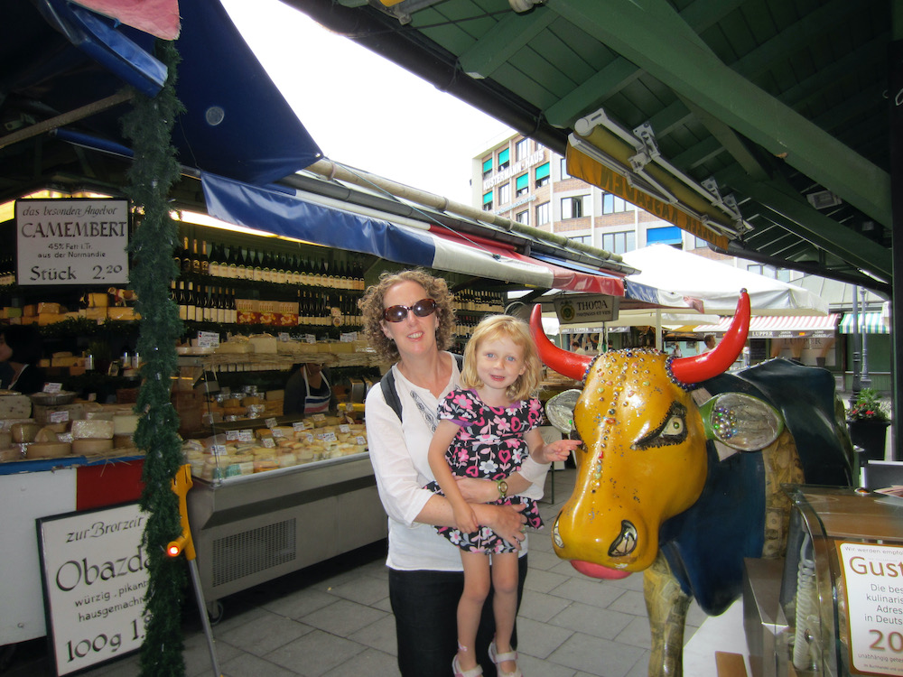 a stern colorful statue of a steer tells you you are in the dairy part of the viktualienmarkt in munich