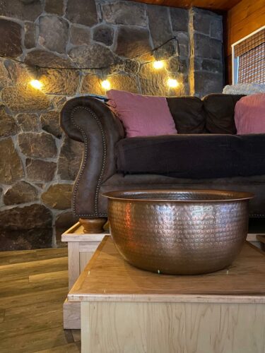A copper foot-soaking tub and cozy love seat set the stage for a foot massage at adk foot sanctuary on main street in lake placid.