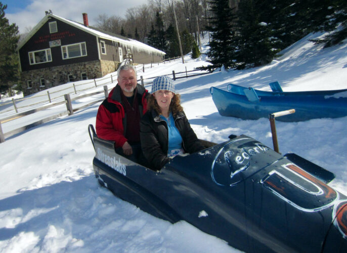 a couple tries out an olympic bobsled at mt. hoevenberg sliding sports center in upstate new york.