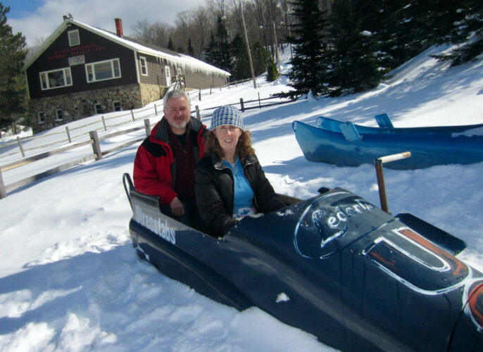 A couple tries out an olympic bobsled at mt. Hoevenberg sliding sports center in upstate new york.