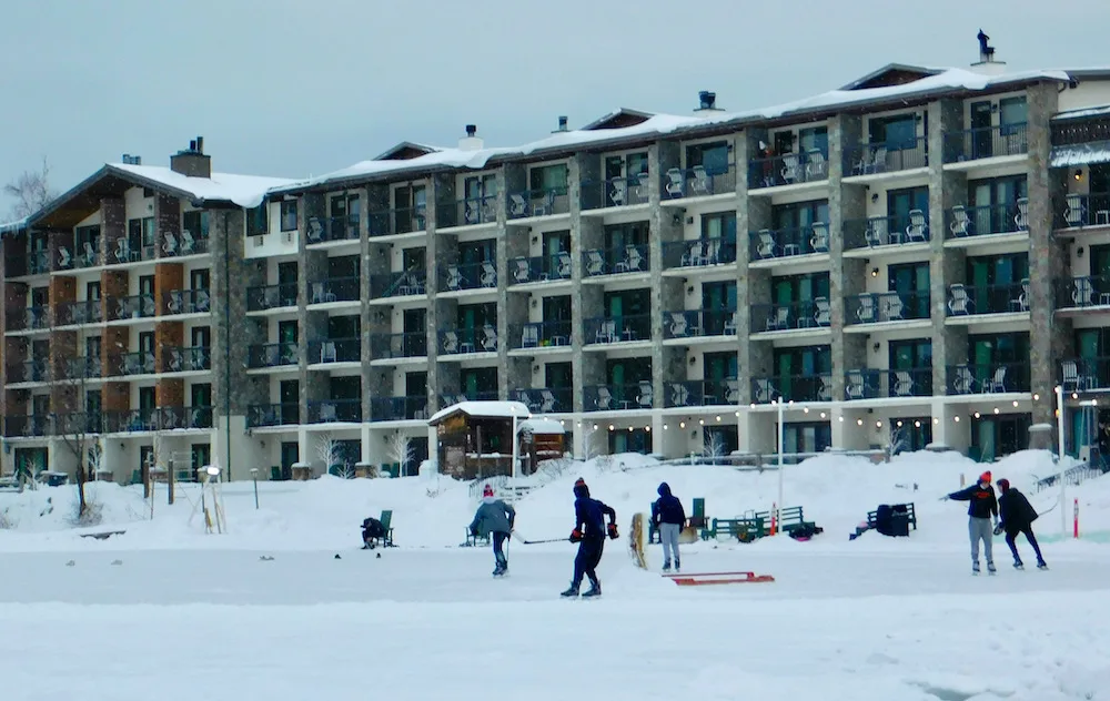 These 2 Lake Placid Hotels Offer Families Great Location, Amenities &Amp; Value kids place ice hocket on a frozen mirror lake outside of the golden arrow hotel in lake placid