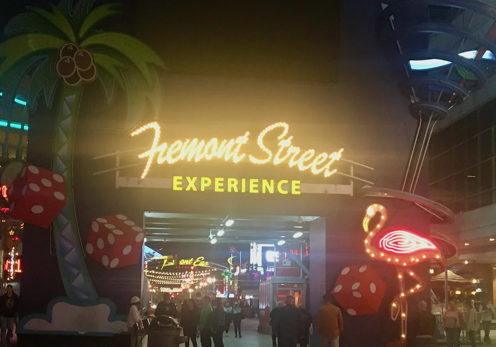 a neon sign announces the fremont street experience in downtown las vegas