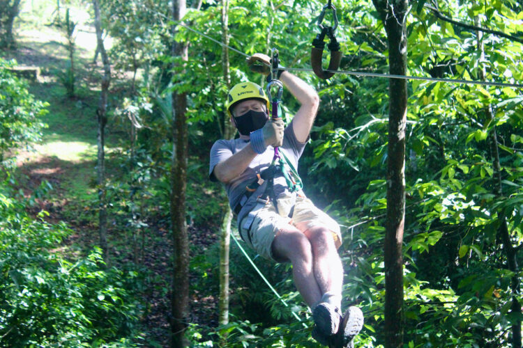 a man flies on a zipline through the costa rica jungle.