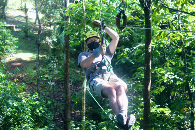 A man flies on a zipline through the costa rica jungle.