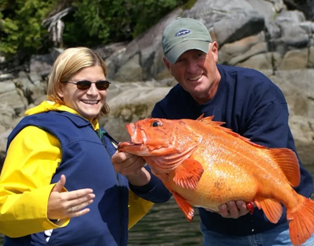 a couple shows off the fish they caught on an carnival alaska cruise -- they'll cook it up back on board the ship