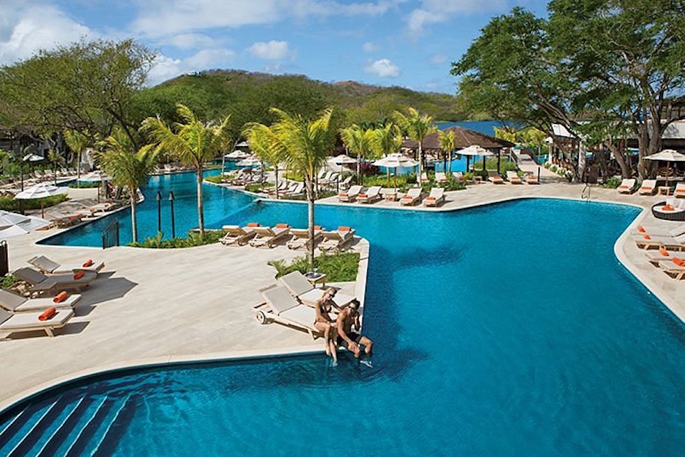 families love te sprawling, winding pool at dreams las mareas resort in costa rica.