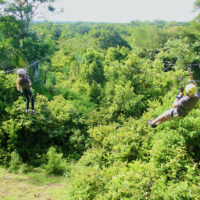 A dad and daugter ride zip-lines in tandem, near Manuel Antonio National Park in Costa Rica