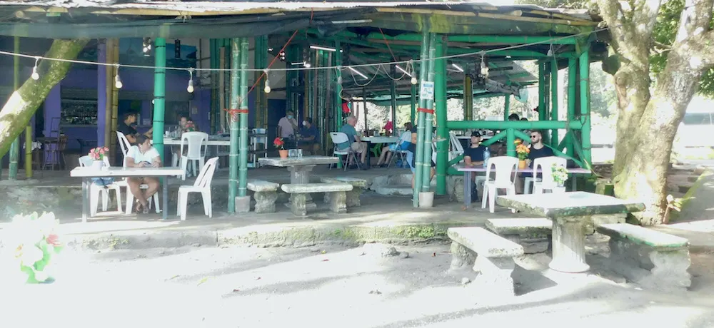 an open air café sits next to the mañuel antonio beach in costa rica