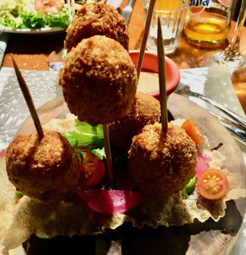 a plate of potato croquettes on upright skewers the parador resort in quepos