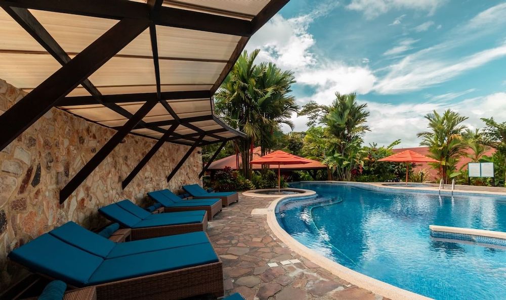 the large pool at rio celeste hideaway in costa rica has 2 shaded hot tubs and plenty of shaded loungers.