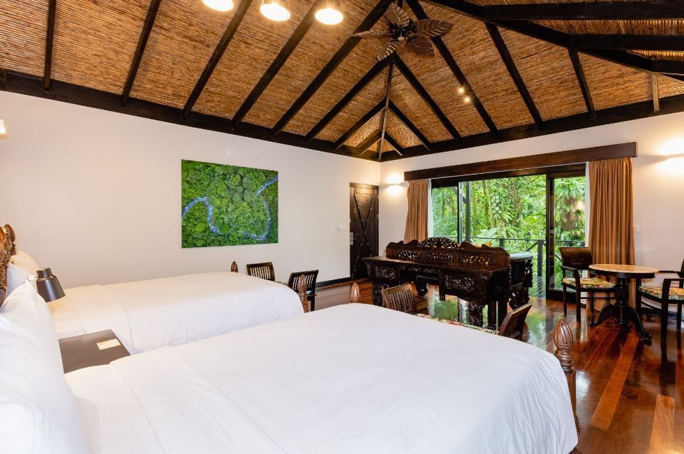 Rio celeste hideway's rooms are big with two beds, dark woods and full-length windows that open onto a porch and green forest