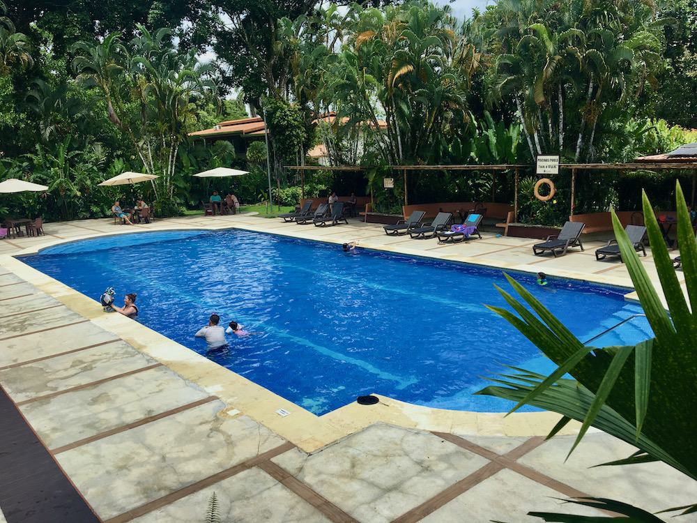 The pool at tilijari resort hotel in costa rica is large and kid-friendly with plenty of tropical trees around it to provide shade.