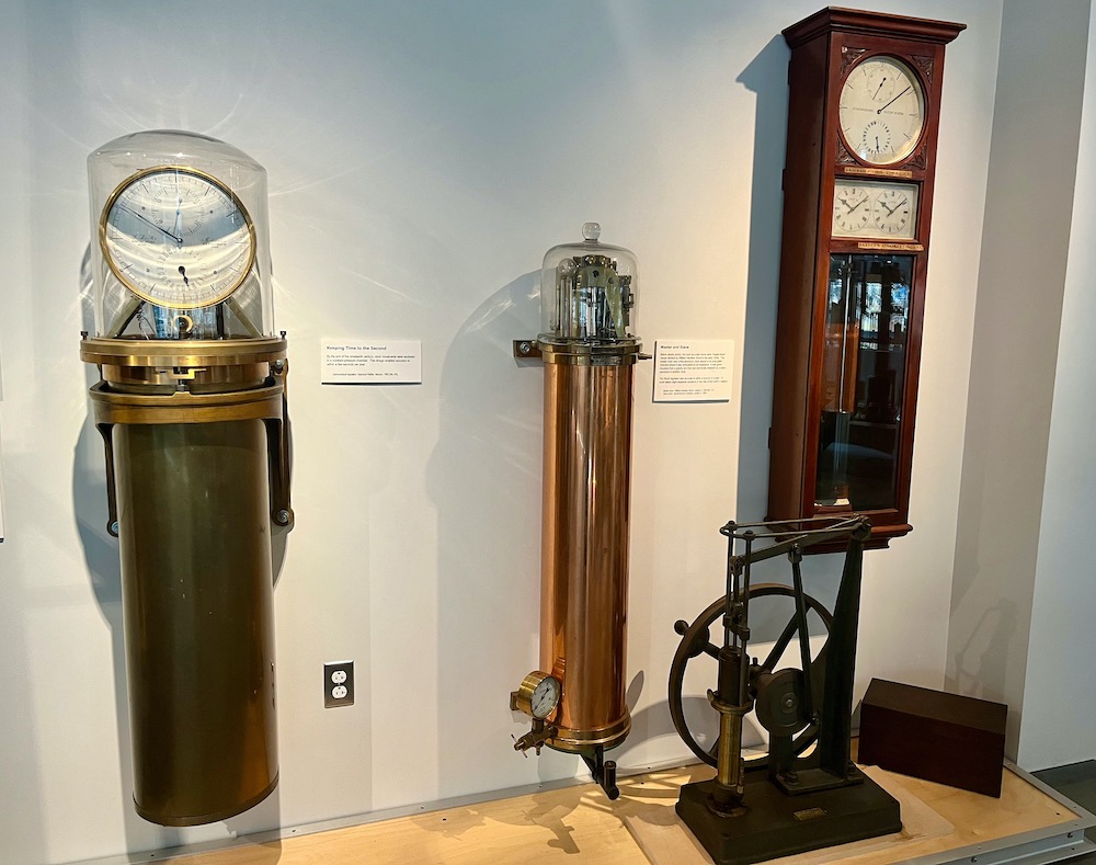 A wall of time-keeping instruments from different periods in the last 200 years, part of harvard's collectionof historic scientific instruments.
