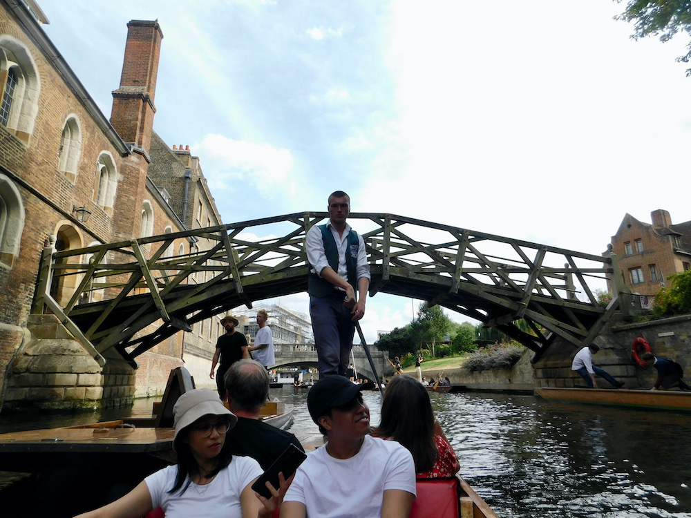 A punt floats under the mathematical bridge on the cam at cambridge.