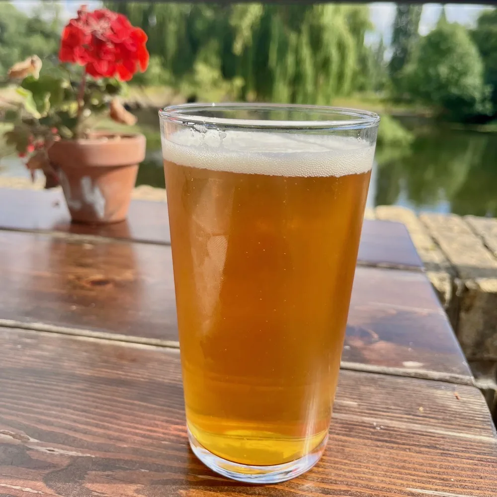 a beer on the deck at granta pub with the river cam behind it.