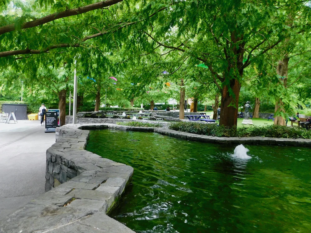 jubilee park on canary whard feels like wonderand with trees, winding raised streams and tucked away places to sit and play.