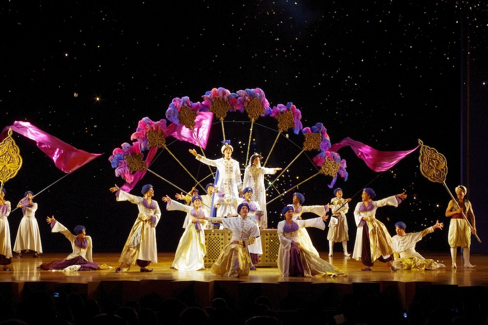 one of the big production numbers in aladdin, featuring a cast with faux-middle-eastern costumes and giants fans made of feathers.