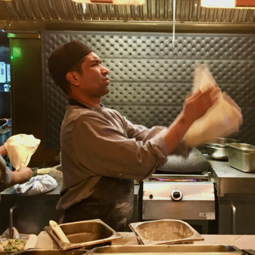 A sous chef tosses bread dough at dishoom indian restaurant in london.