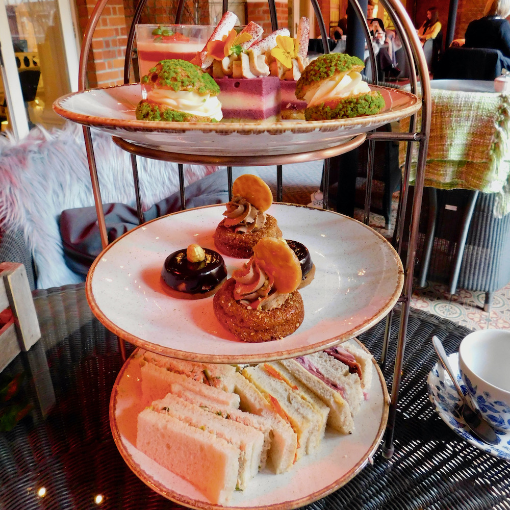 the tea tower at st.ermins hotel includes small sandwiches, fancy cookies and bite-size pastries