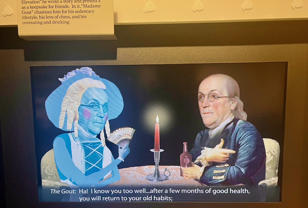 A shot from a video where ben franklin talks with lady gout, a female version of himself, at the ben franklin museum in philadelphia