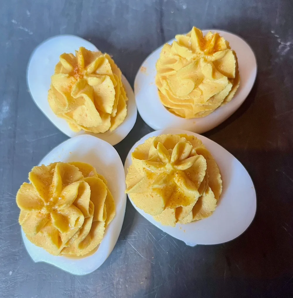 four devilled eggs on a piece of slate at the dandelion pub in philadelphia 