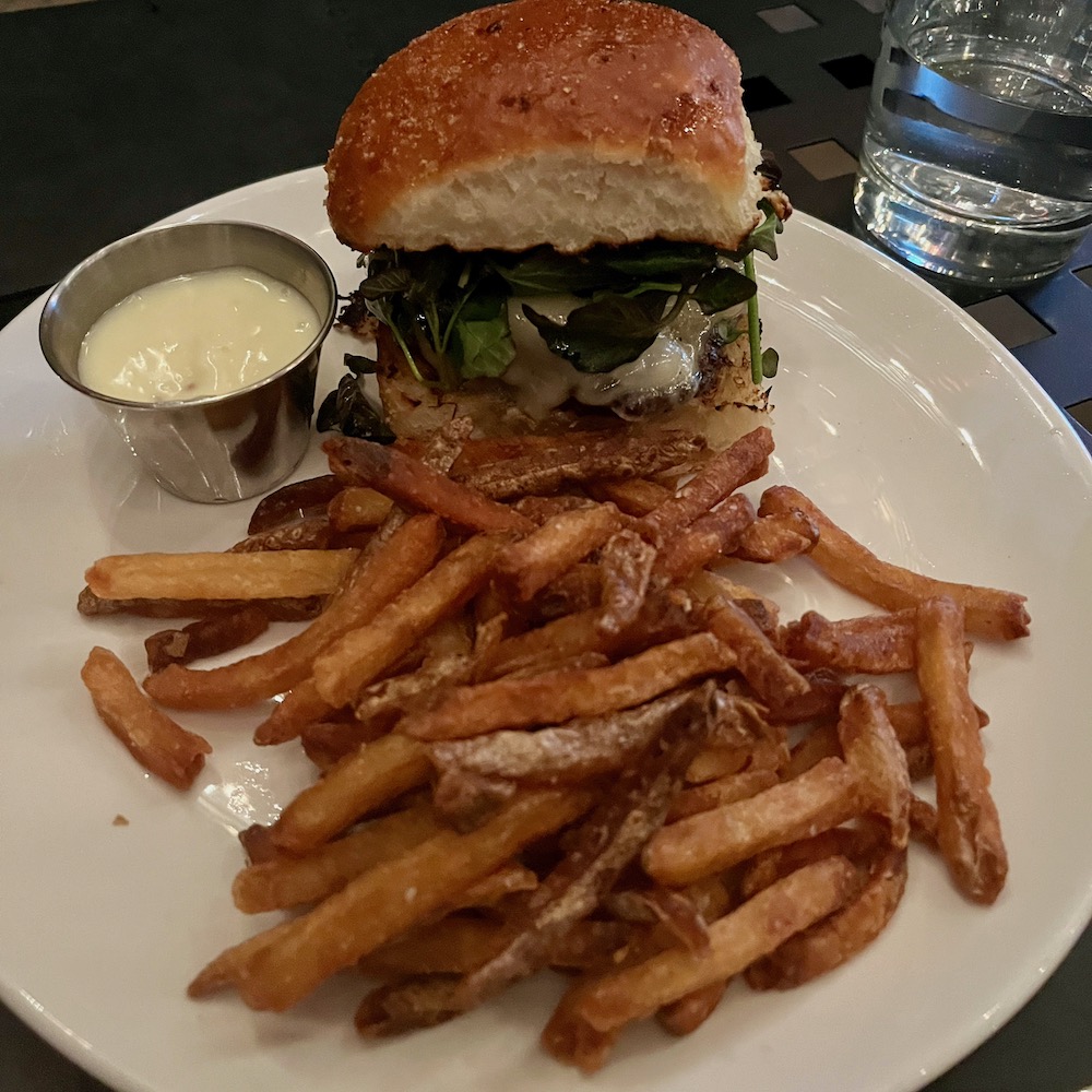 A tall hamburger with watecress and gruyere with french fries and a side of mayonnaise at royal boucherie in philadelphia.