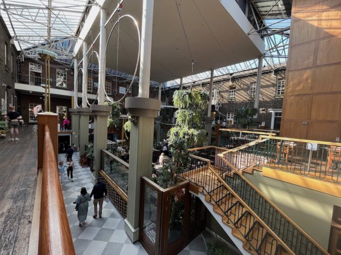 the center of powers court in dublin has a glass ceiling, marble floors and lots of greenery.