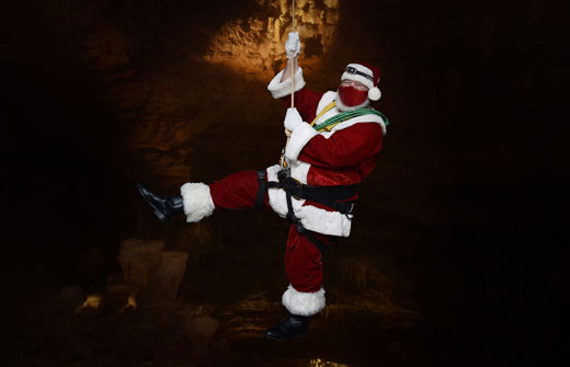 Santa arrives with a rope and carabiners at natural bridge caverns in texas.