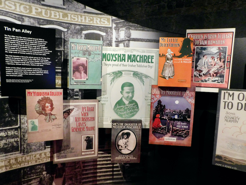 A wall of posters and playbills celebrate irish culture intermingling with jewish, hawaaiian and other cultures trough emigration to the u. S.