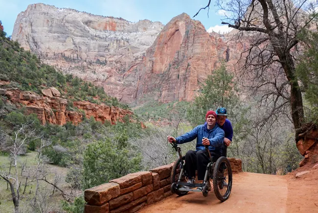 a traveler in a wheelchair takes in the view of zion park along one of its accessible trails.