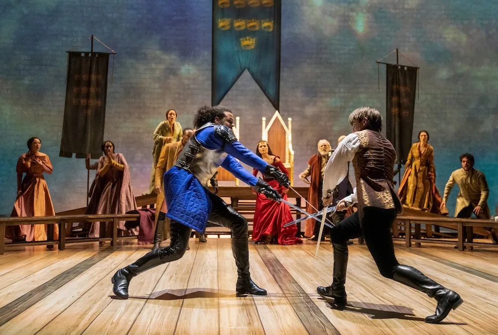 13 Hot Broadway Shows Sure To Be A Hit With Your Teen lancelot and arthur cross swords and guenevere and the court look on.