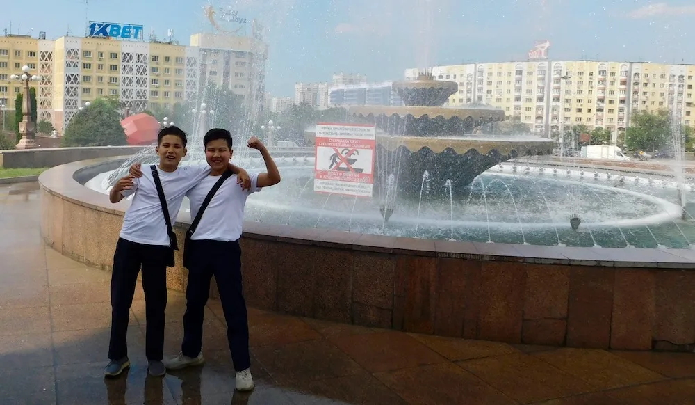 two young boys in first president's park in almaty mug for the camera after showing off their english ability for me.