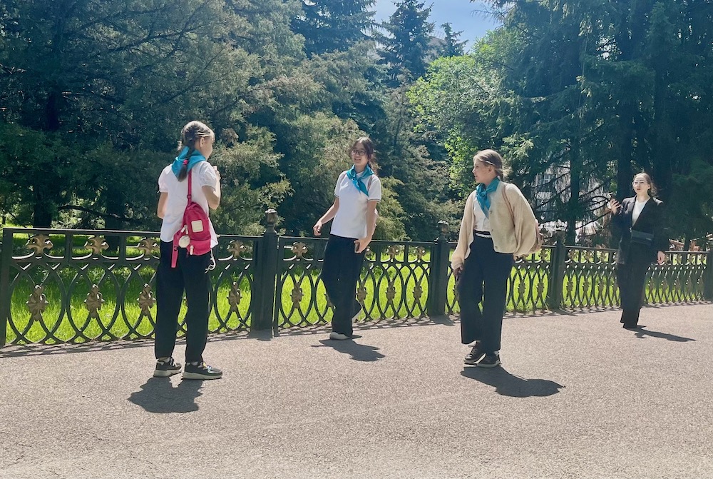 3 teenage girls in almaty wearing school uniform pants, shirts and sneakers  kid arund on their way home from school.