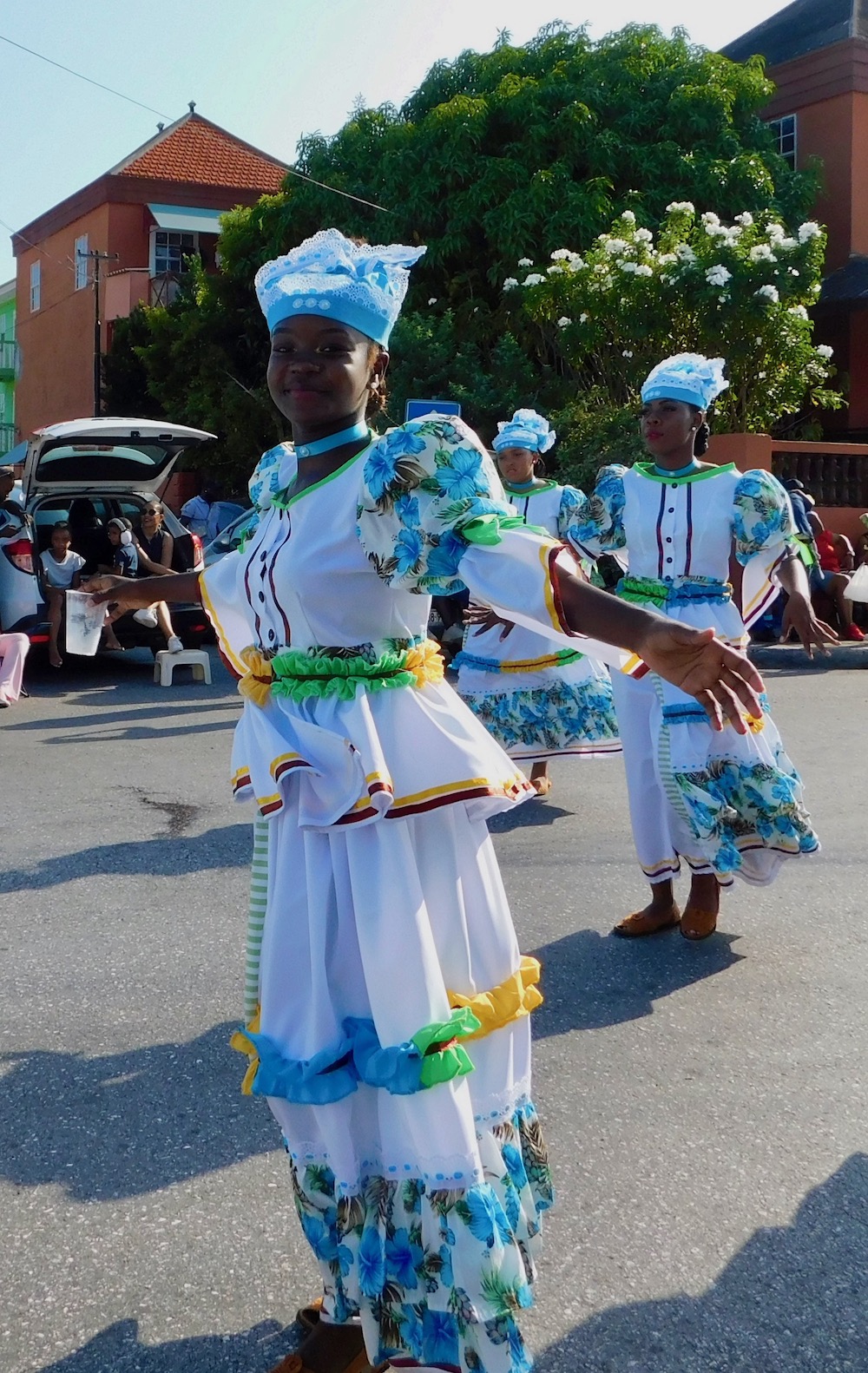 a teen girl shows off her traditional curacao clothes during a local parade.