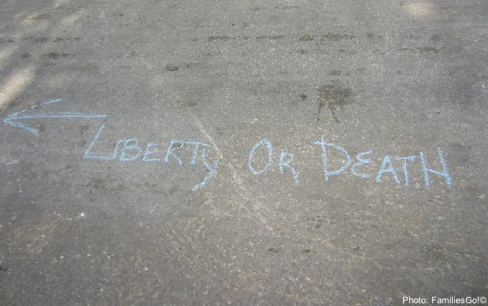 10 Just-Spooky-Enough Family Ghost Tours Near You "liberty or death" written in chalk on the pavement in williamsburg, va