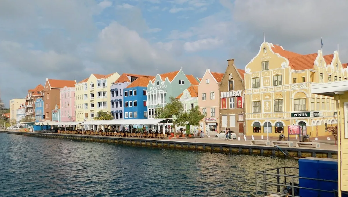 curacao is known for dutch-style buildings in bright yellow, pink, blue, orange and green, like the row of waterfront businesses in willemstad.