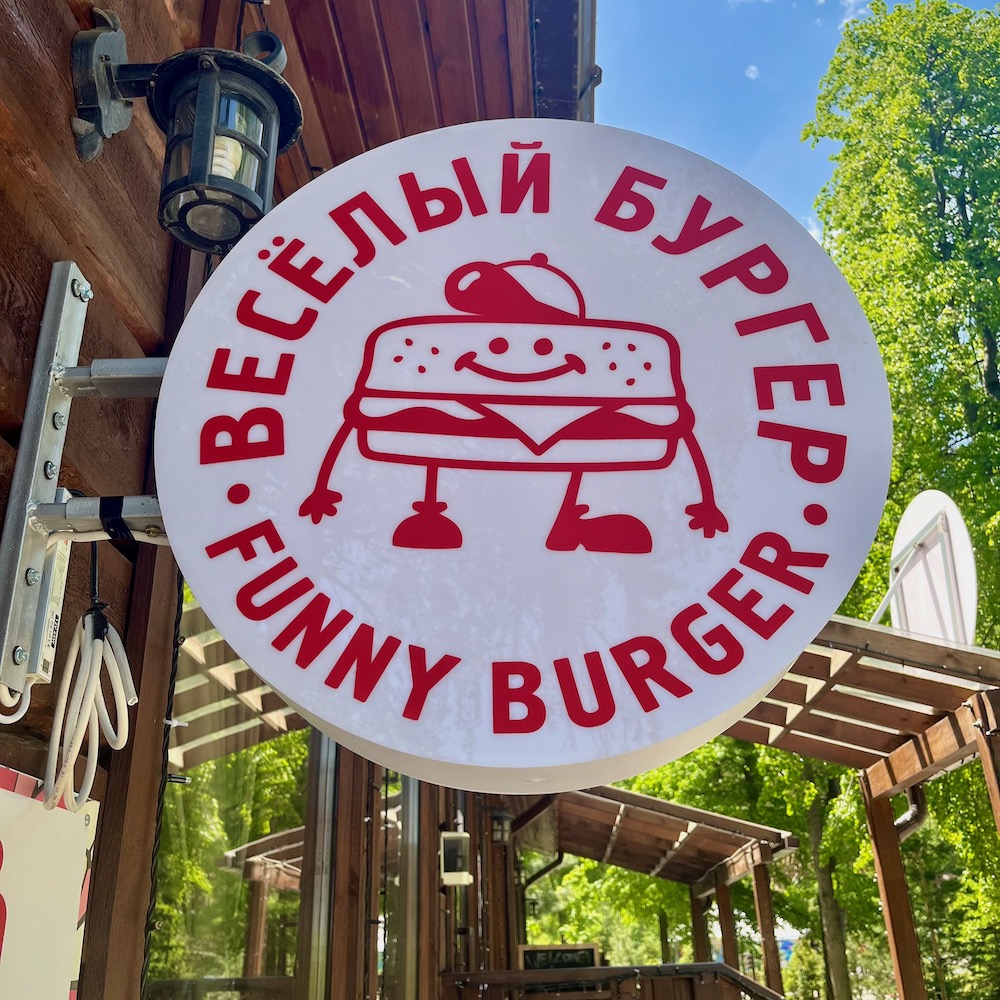 a sign in cyrillic and english for funny burger, a kids will like at the oi qaragai resort 