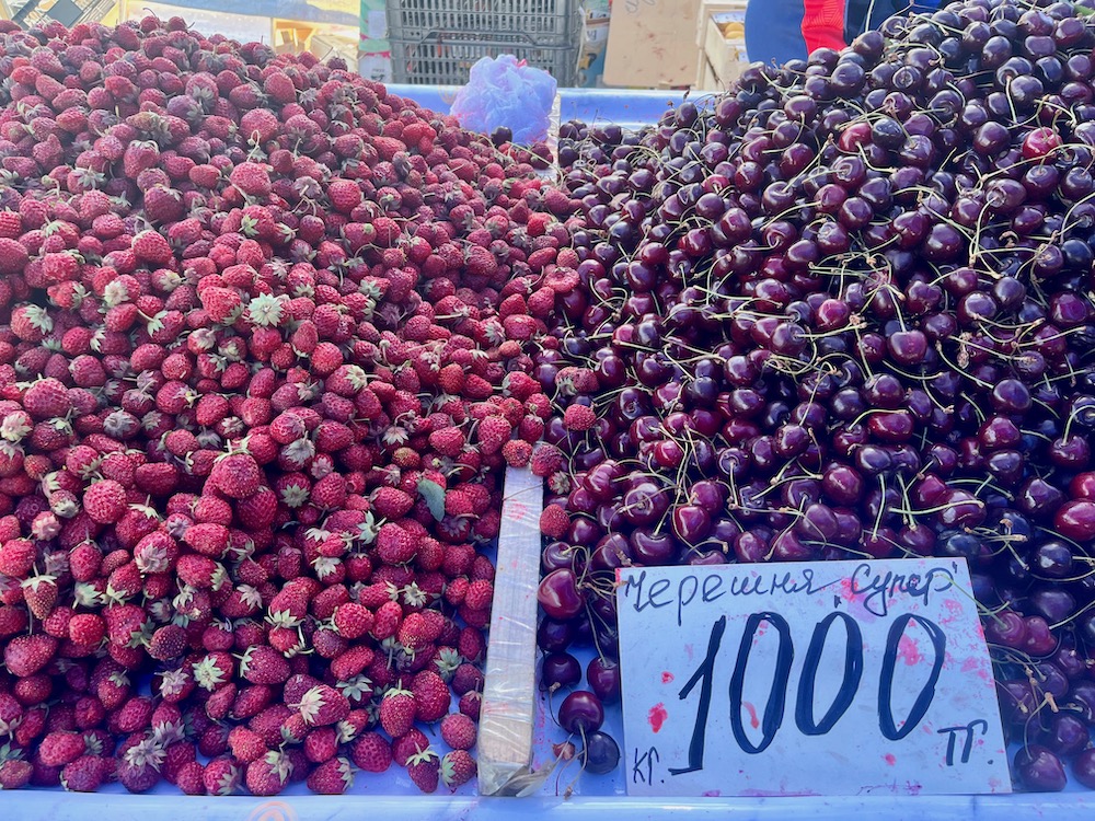 Piles of fresh strawberries and cherries at kazakhstan's green bazaar